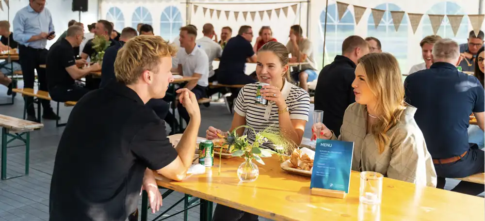 Gæster til firmaarrangement spiser burgere fra The Burgery i et festtelt